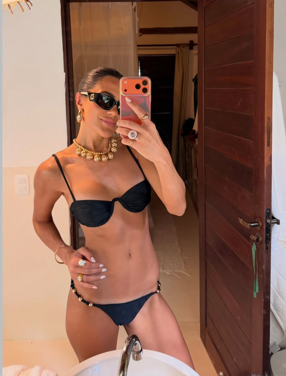 Beachwear — biquíni preto com joias douradas